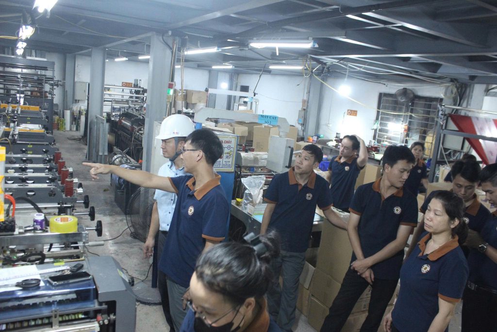 Cán bộ kỹ thuật Bao Bì Tâm Thành hướng dẫn quy trình vận hành an toàn máy cắt cho công nhân nhà xưởng